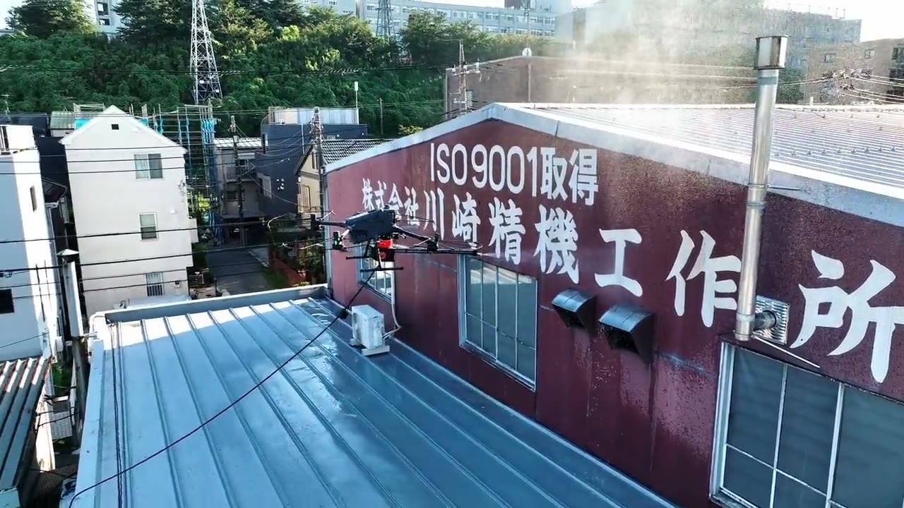 ドローンでビル外壁を高圧洗浄している様子